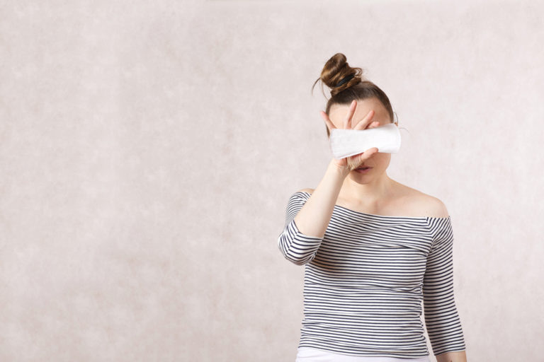 woman holding a panty liner in front of her eyes