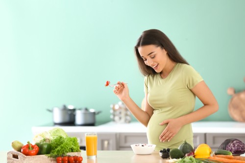 pregnant woman eating vegetables and fruits 