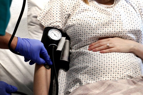 pregnant woman getting blood pressure checked 