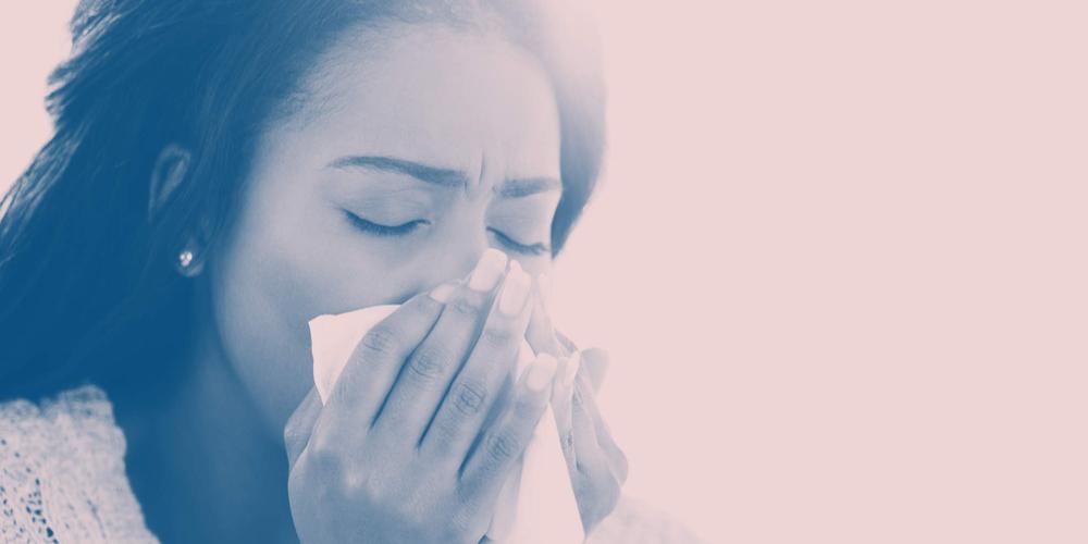 female coughing with a tissue covering her mouth