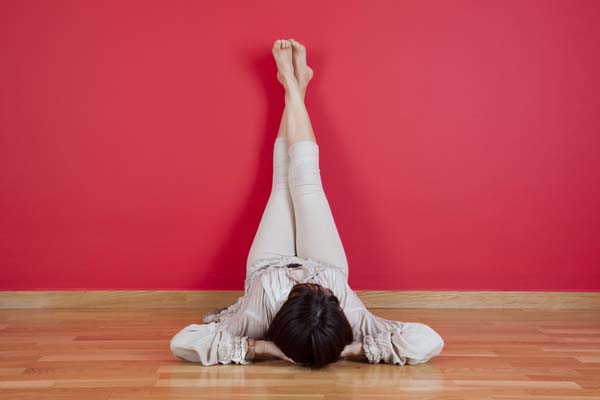 Girl on the floor with legs up the wall