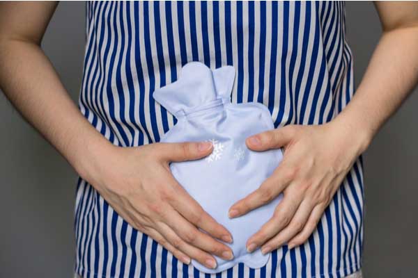 Women applying heat to the stomach