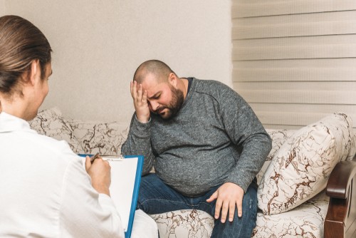 fat man sitting worried at a doctor's clinic