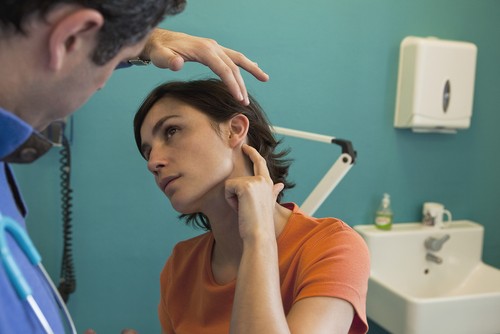 ENT specialist checking a woman's ear