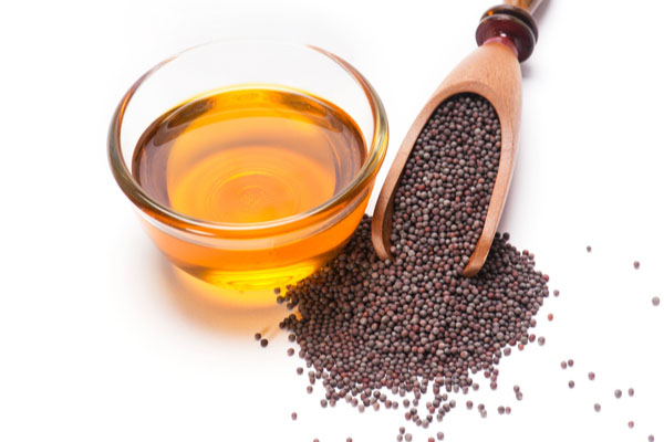 Mustard oil in a bowl with seeds