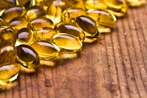 cod liver tablets on wooden table