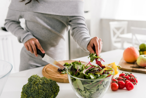 woman cutting green vegetables 