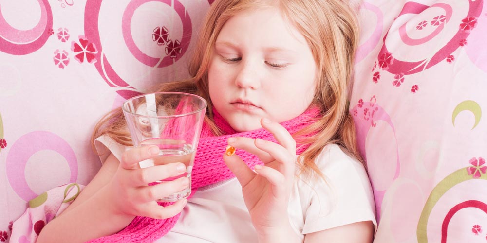 A sick girl staring at the glass and medicine