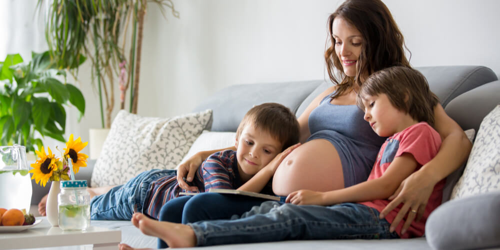 pregnant woman and her son on a bed