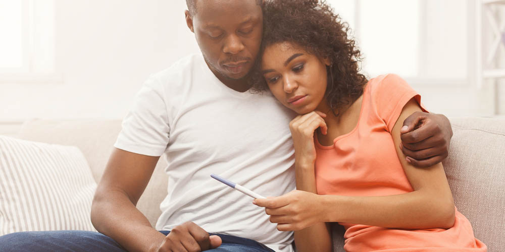 stressed couple holding negative pregnancy test