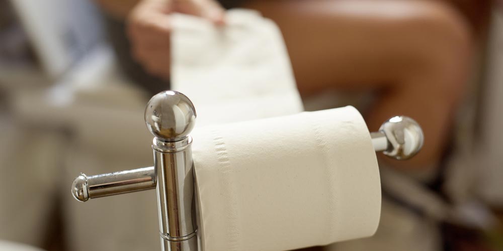 man on toilet seat troubles with constipation