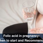 pregnant female holding folic acid supplement in hand