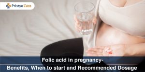 pregnant female holding folic acid supplement in hand