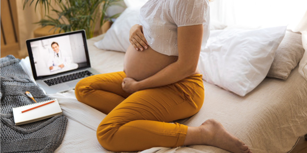 pregnant female consulting her doctor online via video call
