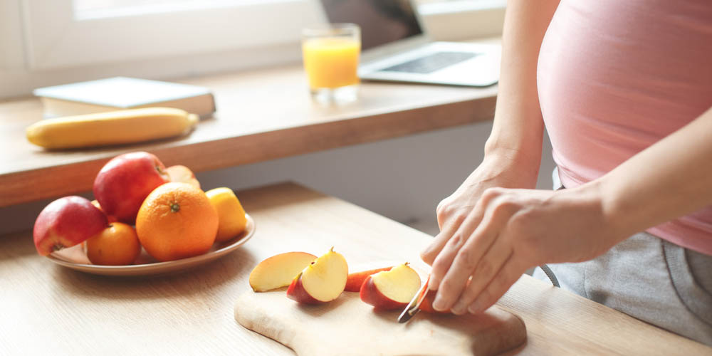 pregnant female cutting apples