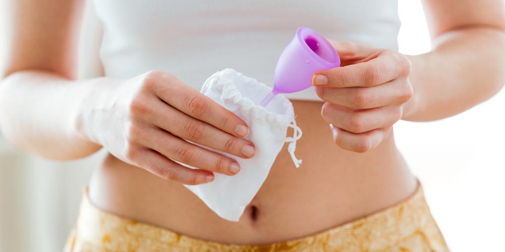 female holding a menstrual cup