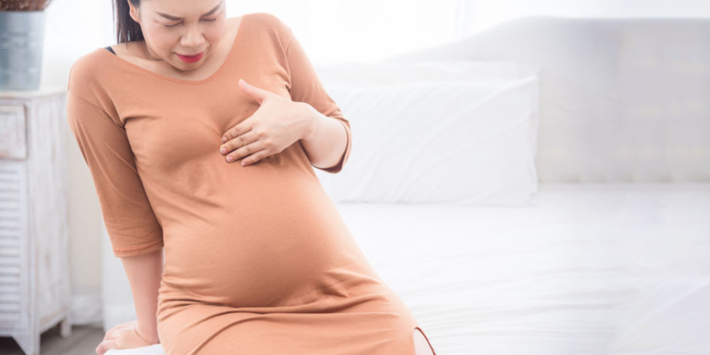 pregnant female having heartburn