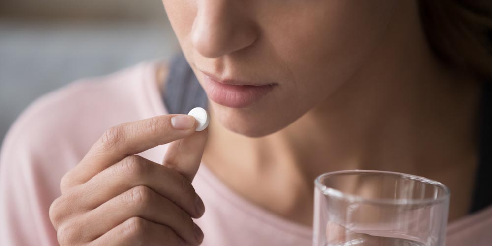 female taking a pill