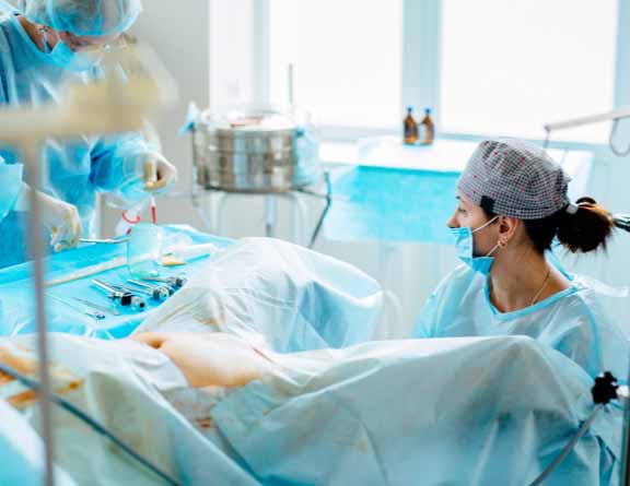 Gynecologists performing hysteroscopy on female patient