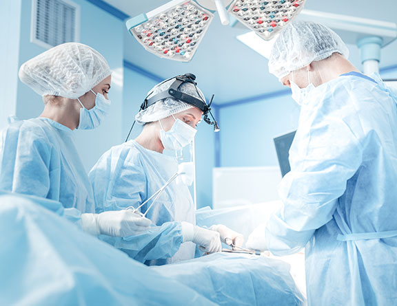 Surgeons performing pilonidal sinus on patient