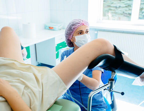 Gynecologist performing vaginoplasty surgery on female patient