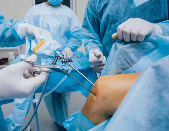 Doctor performing arthroscopy surgery on patient