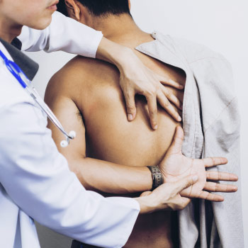 Doctor checking back pain in a patient 